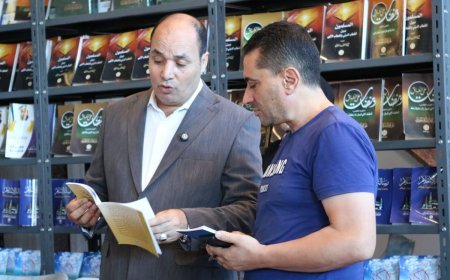 Mohamed Fathi El-Sherif obsequia las obras de Ali Mohamed El-Shorafa al director de la biblioteca "Tweety" en Alejandría, en el marco de la Feria Internacional del Libro de la Biblioteca de Alejandría